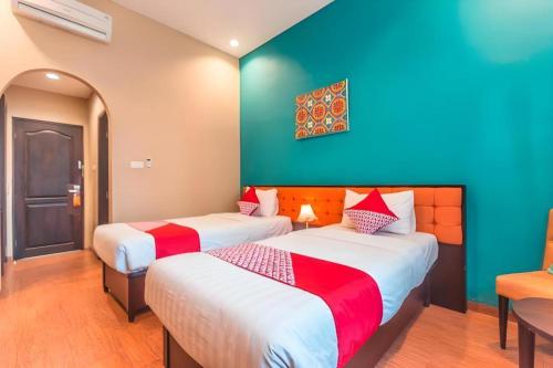 two beds in a room with blue and green walls at Ole Suite Hotel in Bogor