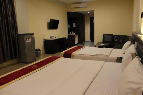a hotel room with two beds and a television at Balai View Hotel in Tanjung Balai Karimun