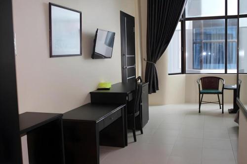 a room with a desk and a tv on a wall at Balai View Hotel in Tanjung Balai Karimun