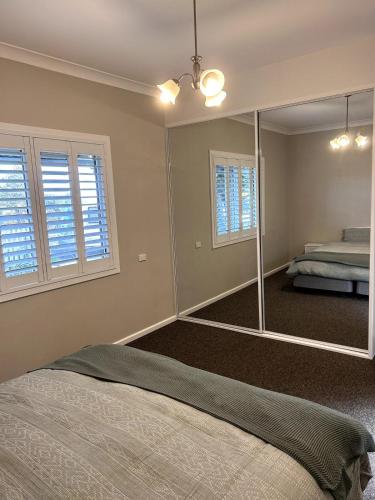 a bedroom with a large mirror and a bed at Cosy Family Cottage in Katoomba