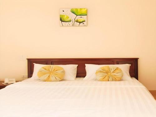 a bedroom with a bed with two pillows on it at Huong Binh Hotel in Da Nang