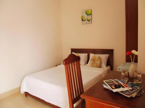 a bedroom with two beds and a desk with a table at Huong Binh Hotel in Da Nang