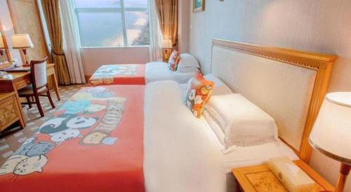 a bedroom with two twin beds with hello kitty sheets at Zhuhai Dehan Hotel in Zhuhai