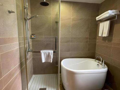 a bathroom with a shower with a toilet and a sink at Harbour Bay Hotel in Hong Kong