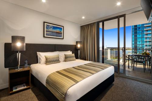 una camera d'albergo con un letto e un balcone di Quest East Perth a Perth