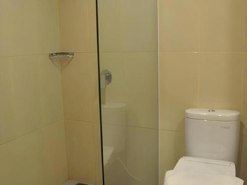 a bathroom with a toilet and a glass shower at Evora Hotel in Surabaya
