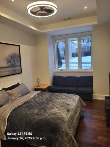 a bedroom with a bed and a couch and a window at Hillcrest Modern House in Toronto
