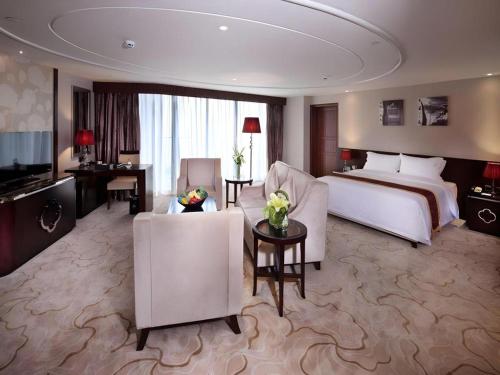 a large hotel room with a bed and a desk at SUN Yat-sen university Hotel and Conference Centre in Guangzhou