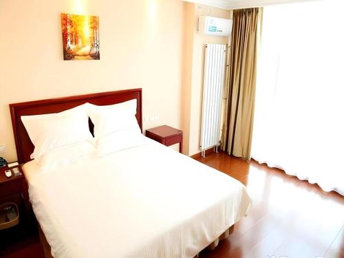 a bedroom with a white bed and a large window at GreenTree Inn Beijing East Yizhuang District Second Kechuang Street Express Hotel in Beijing