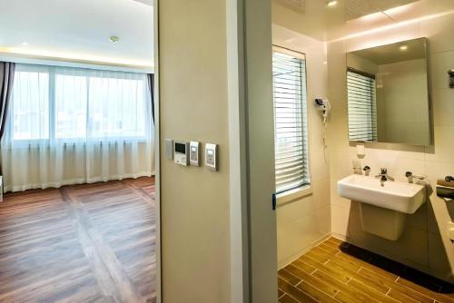 a bathroom with a sink and a mirror at Galaxy Hotel in Jeju