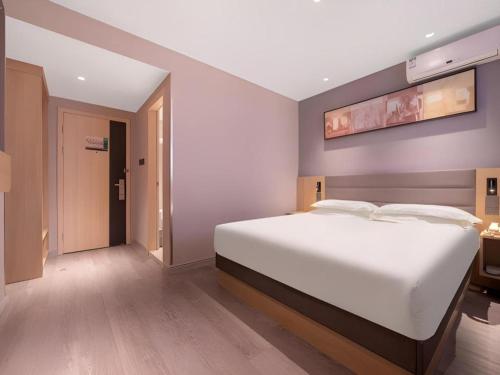 a bedroom with a large white bed in a room at Jinjiang Inn Quanzhou West Street Kaiyuan Temple in Quanzhou