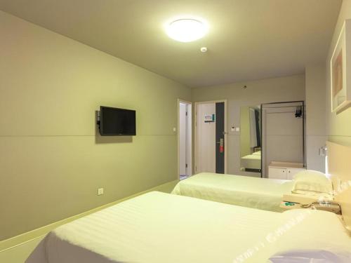 a hospital room with two beds and a tv at Jinjiang Inn Quanzhou West Street Kaiyuan Temple in Quanzhou