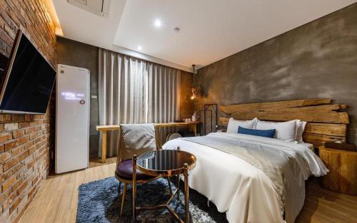 a bedroom with a large bed and a brick wall at Daejeon Namoo Hotel in Daejeon