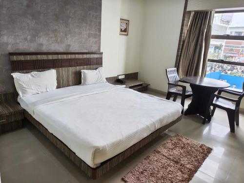 a bedroom with a bed and a table and chairs at Collection O Aurangabad Central Bus Terminal in Aurangabad