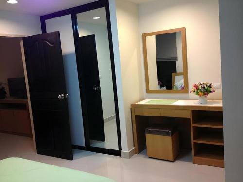 a bathroom with a large mirror and a sink at Ipremium Sukhumvit 81 Hotel in Bangkok