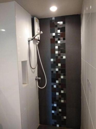 a shower in a bathroom with a tile wall at Wsotel Hotel in Songkhla