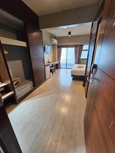 a large room with a bed and a room with a desk at Wsotel Hotel in Songkhla