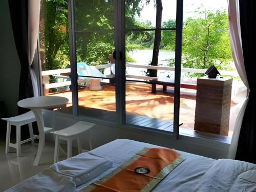 - une chambre avec une grande fenêtre donnant sur un patio dans l'établissement Rommai Rimnaam Resort, à Ban Bang Rin (1)