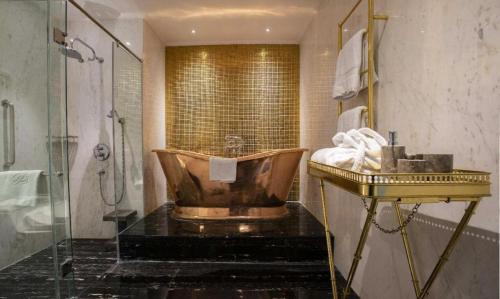 a bathroom with a copper tub and a shower at Lafayette Boutique Hotel in Yogyakarta