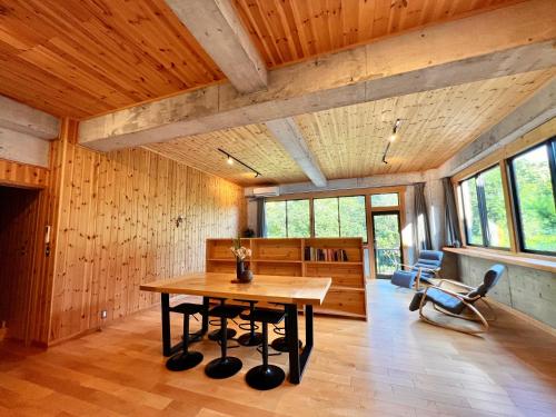 a wooden room with a table and chairs in it at TATEYA VACATION Cozy spacious suite by the creek in Akiruno
