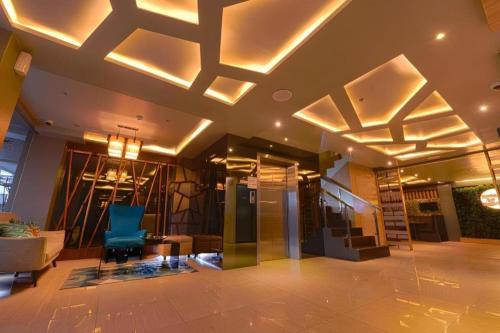 a lobby with a blue chair and a staircase at Hotel Estrella in Tacloban