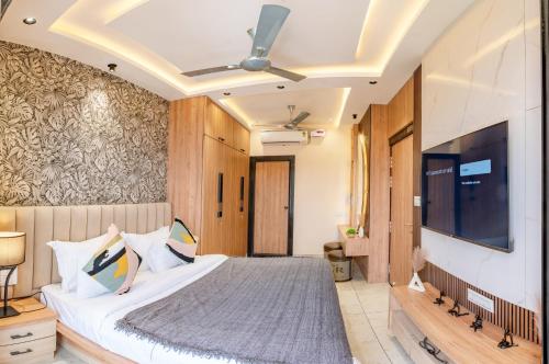 a bedroom with a large bed and a flat screen tv at Boutique Apartments By One Tree in Jodhpur