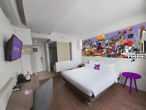 a bedroom with a white bed and a painting on the wall at Royal Bay Hotel Makassar in Makassar