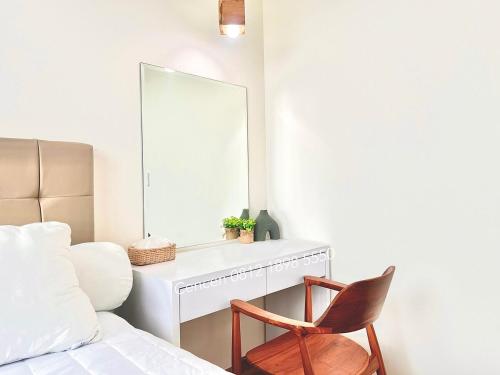 a bedroom with a mirror and a chair next to a bed at Quality Beds with Golf View at Fairview Millenium Village, Lippo Karawaci in Dadap