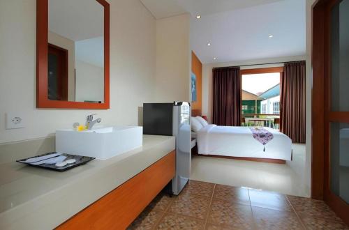 a bathroom with two white sinks and a mirror at Umah Bali Suites in Denpasar