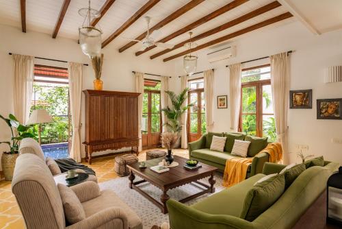 a living room with couches and a table at La Morena by The Blue Kite - Luxurious & Spacious 4 BHK villas in Assagao, Private Pool, Balcony, Kitchen, Patio and Security in Assagao