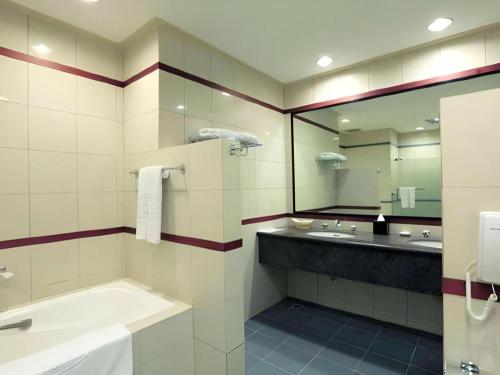 a bathroom with two sinks and a large mirror at Hotel Niagara Parapat in Parapat