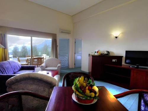 a living room with a table with a bowl of fruit at Hotel Niagara Parapat in Parapat