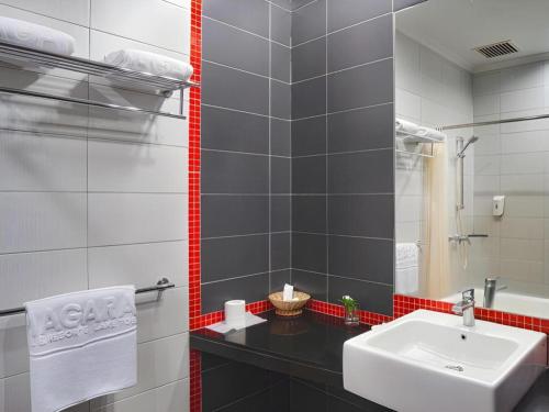 a bathroom with a sink and a mirror at Hotel Niagara Parapat in Parapat
