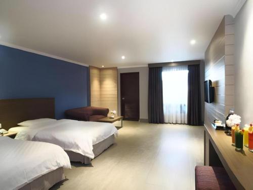a hotel room with two beds and a television at Hotel Niagara Parapat in Parapat