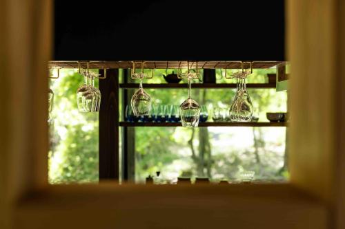 a window with a bunch of chandeliers hanging from it at blue in green 飯田高原 cottage and cafe in Iida