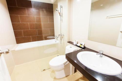 a bathroom with a white toilet and a sink at B2 Sriracha Premier Hotel in Si Racha