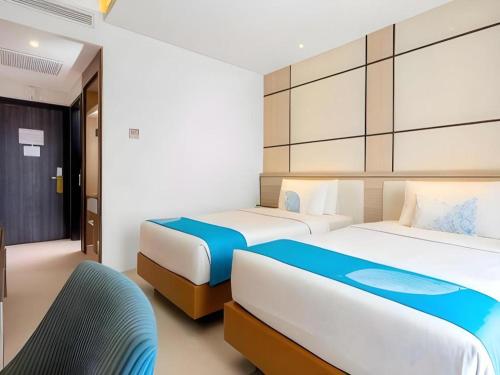 two beds in a room with two beds sidx sidx sidx sidx at Java Lotus Hotel Jember in Jember
