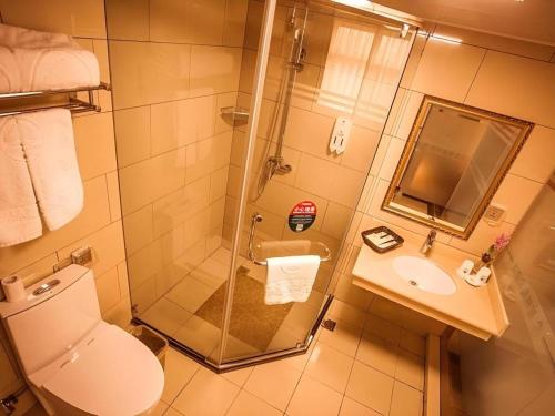 a bathroom with a shower and a toilet and a sink at GreenTree Inn Xi'an Yanta District Dayanta Furongyuan Hotel in Xi'an