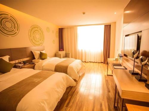 a hotel room with two beds and a window at GreenTree Inn Xi'an Yanta District Dayanta Furongyuan Hotel in Xi'an