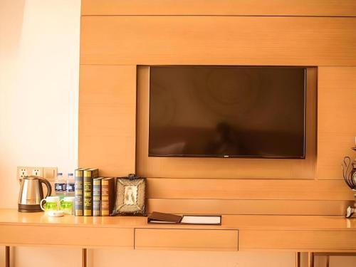 a flat screen tv mounted on a wall at GreenTree Inn Xi'an Yanta District Dayanta Furongyuan Hotel in Xi'an