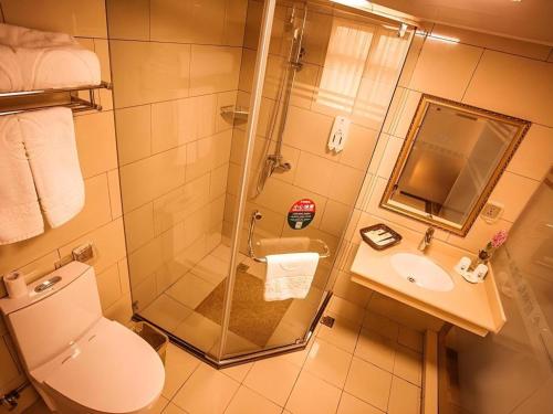 a bathroom with a shower and a toilet and a sink at GreenTree Inn Xi'an Yanta District Dayanta Furongyuan Hotel in Xi'an