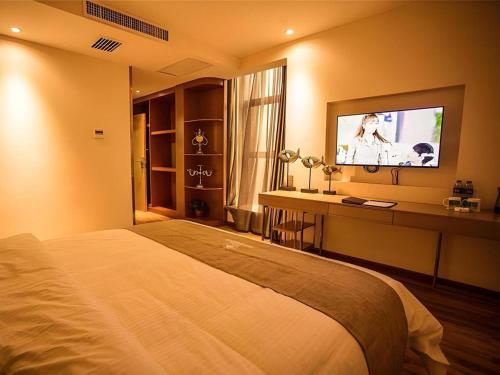 a bedroom with a bed and a flat screen tv at GreenTree Inn Xi'an Yanta District Dayanta Furongyuan Hotel in Xi'an