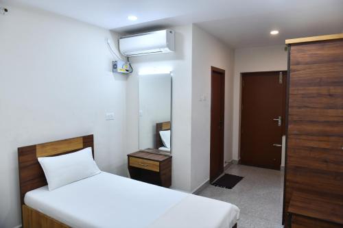 a small bedroom with a bed and a mirror at RRR Residency in Vellore