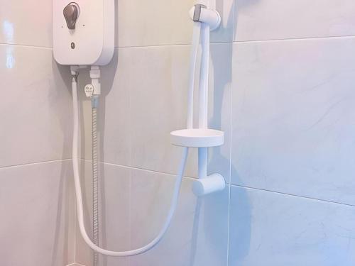 a shower in a bathroom with a phone on the wall at Kosit One Hotel in Ban Bung Sam Phan Nok