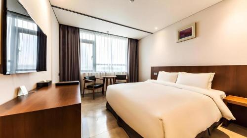 a hotel room with a large bed and a table at CS Premier Hotel in Seoul