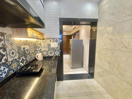 a kitchen with a stove and a refrigerator at Boutique Apartments By One Tree in Jodhpur