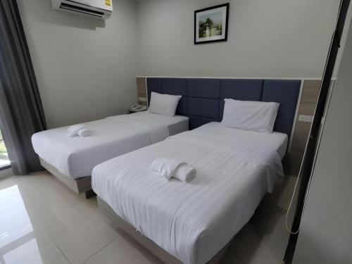 two beds with white sheets in a room at Sattahip 9 Boutique Hotel in Pattaya Central