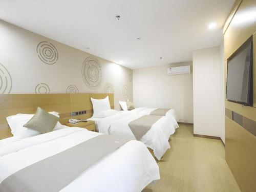 Una cama o camas en una habitación de GreenTree Inn Zhangjiagang Yangshe Old Street Stadium