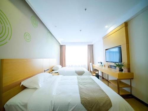 Una cama o camas en una habitación de GreenTree Inn Zhangjiagang Yangshe Old Street Stadium