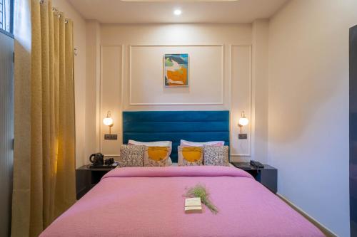 a bedroom with a large bed with a pink blanket at Aalaya Suites By Perfect Stayz in Haridwār
